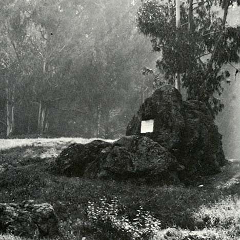 Black and white photo of a rock with a plaque